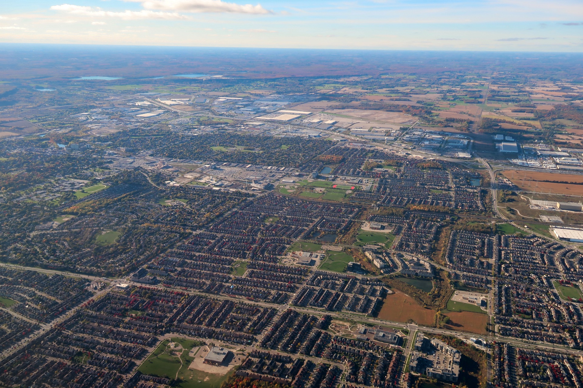An aerial view over Milton showing the residential streets, town centre and wider rural landscape, photographed in 2024